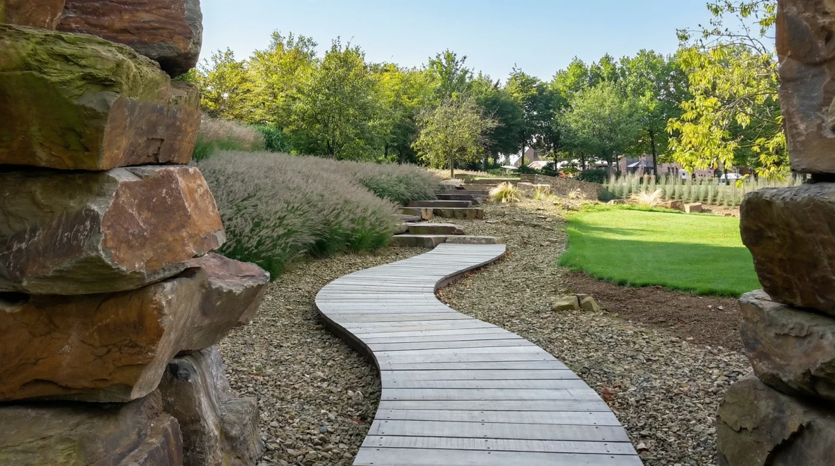 Chemin sinueux en bois traversant un jardin de rochers