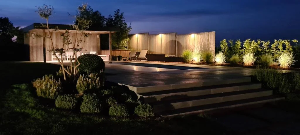 Pool house et terrasse avec éclairage paysager de nuit